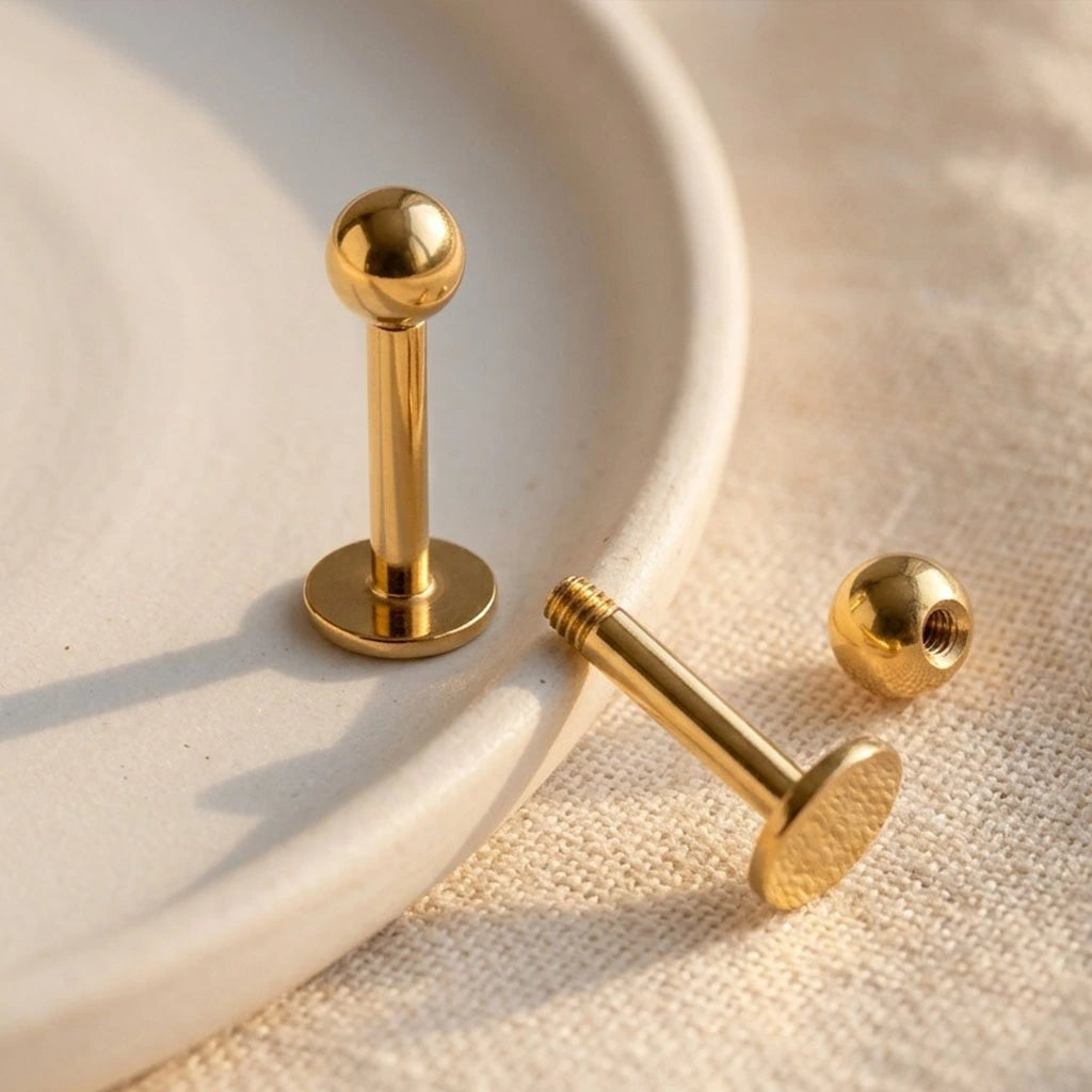 Gold metal studs on a textured beige surface