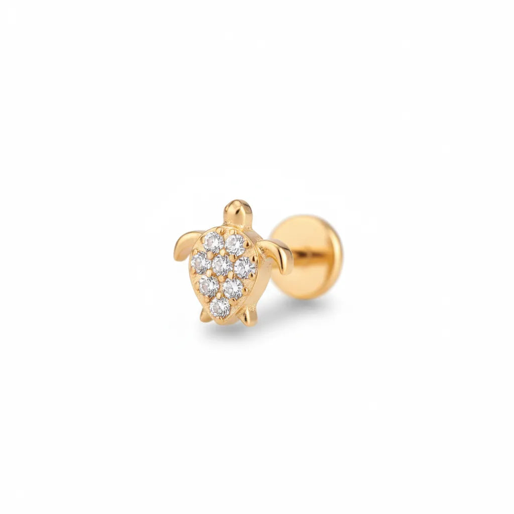 Gold turtle-shaped earring with embedded diamonds on a white background