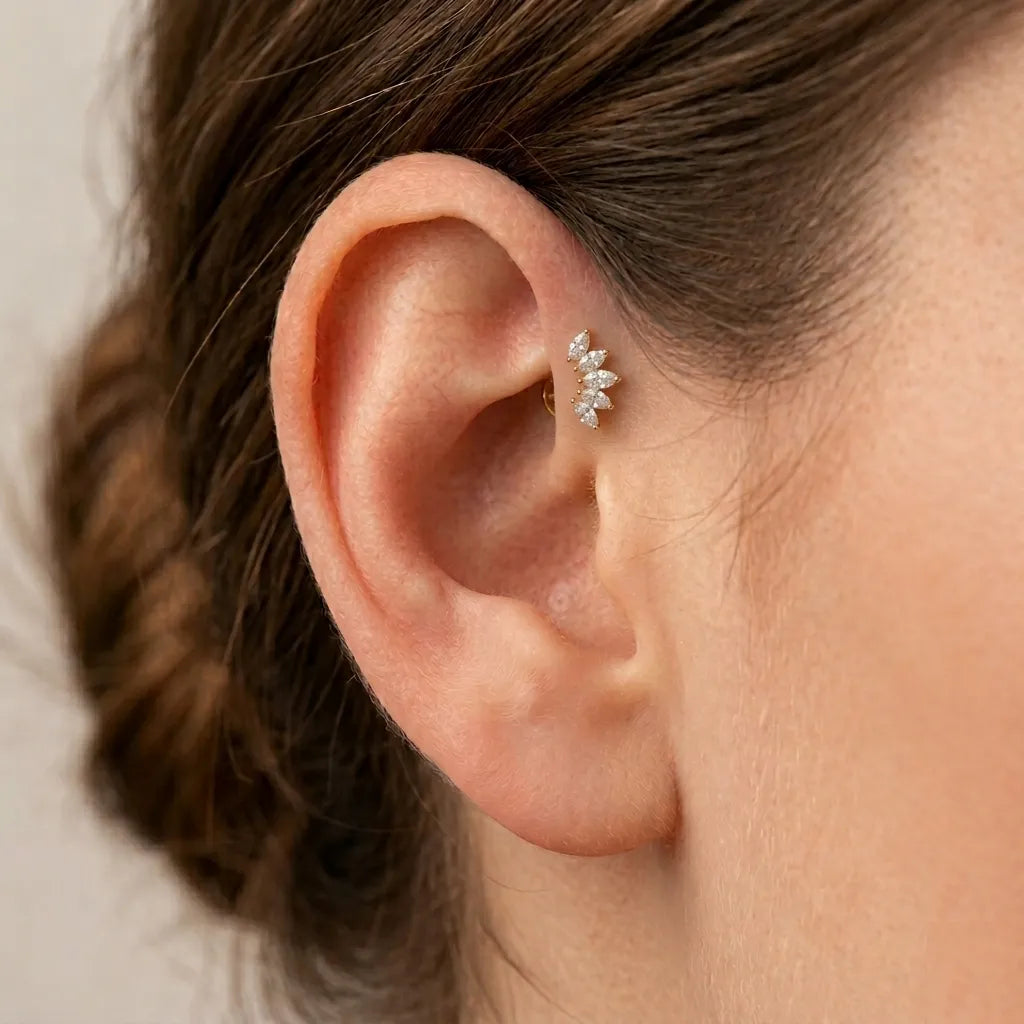 Close-up of ear wearing gold cubic zirconia stacked titanium piercing