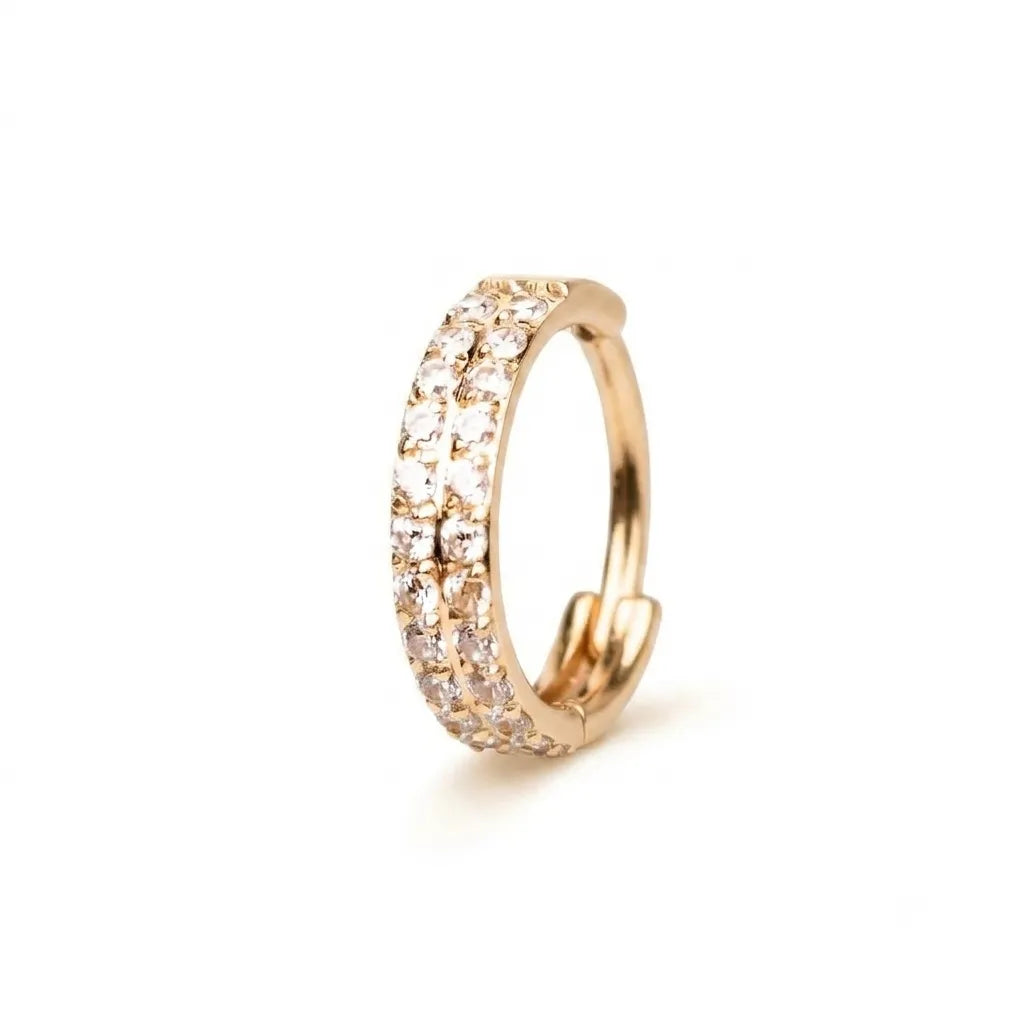 A rose gold huggie hoop ring adorned with three rows of clear pavé gemstones, shown on a clean white background.