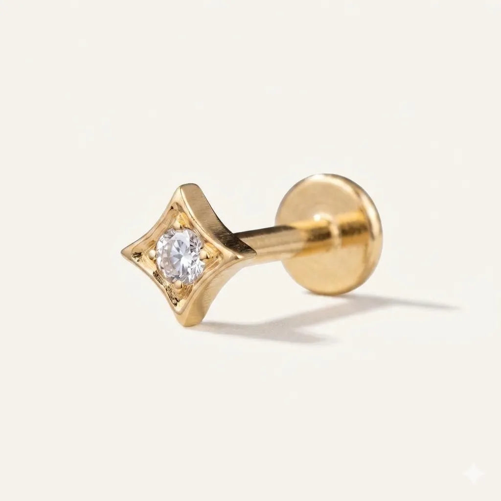 Gold implant grade titanium star labret stud with cubic zirconia centre stone on white background