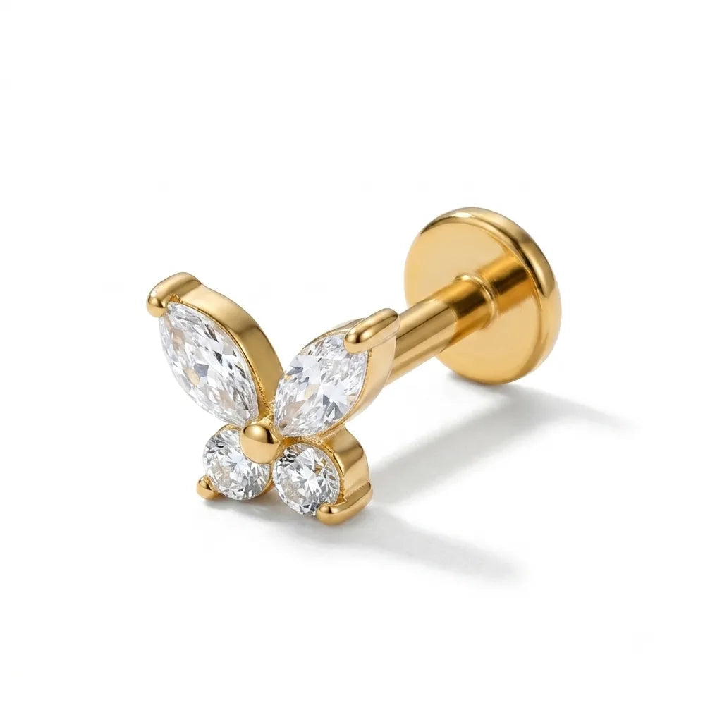 Gold butterfly-shaped earring with clear gemstones on a white background