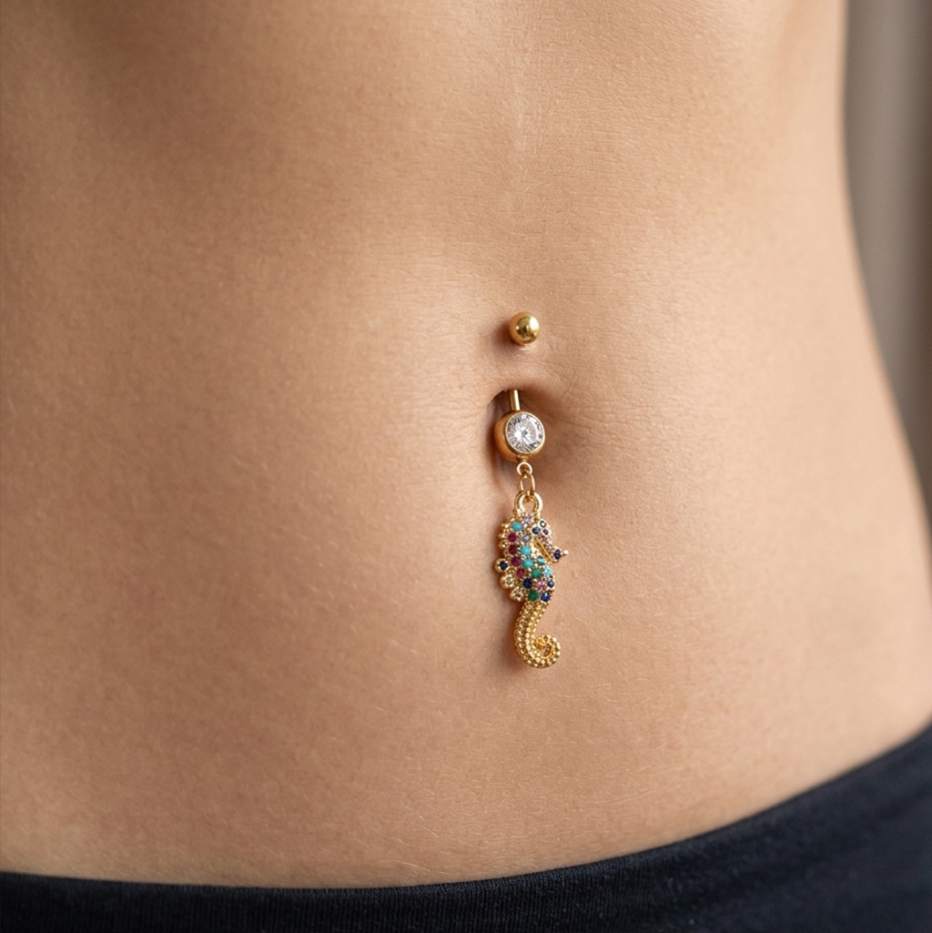 Belly button ring with a seahorse charm on a person's belly.