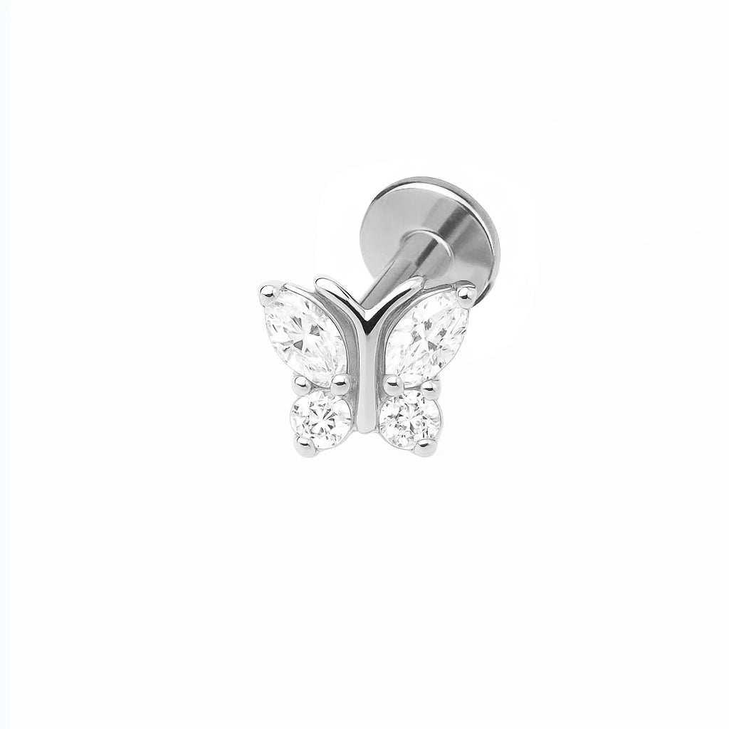 A gold-colored titanium piercing featuring a butterfly design with clear crystals.