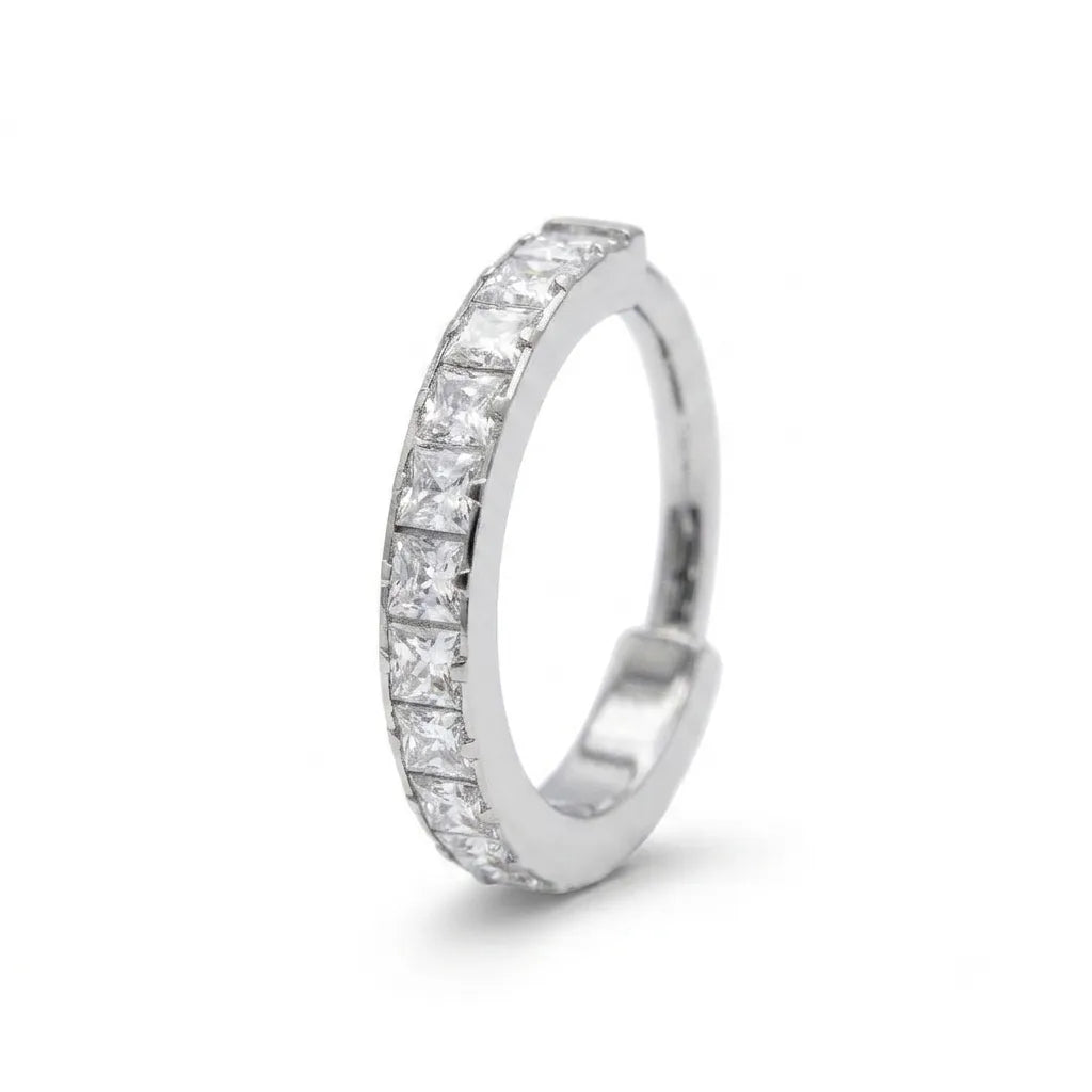 A silver-colored huggie hoop ring featuring a continuous row of princess-cut clear stones, shown on a clean white background.