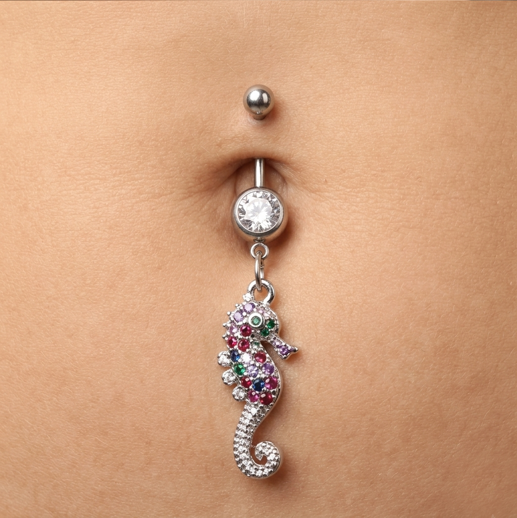 Belly button ring with a seahorse design on a person's belly.