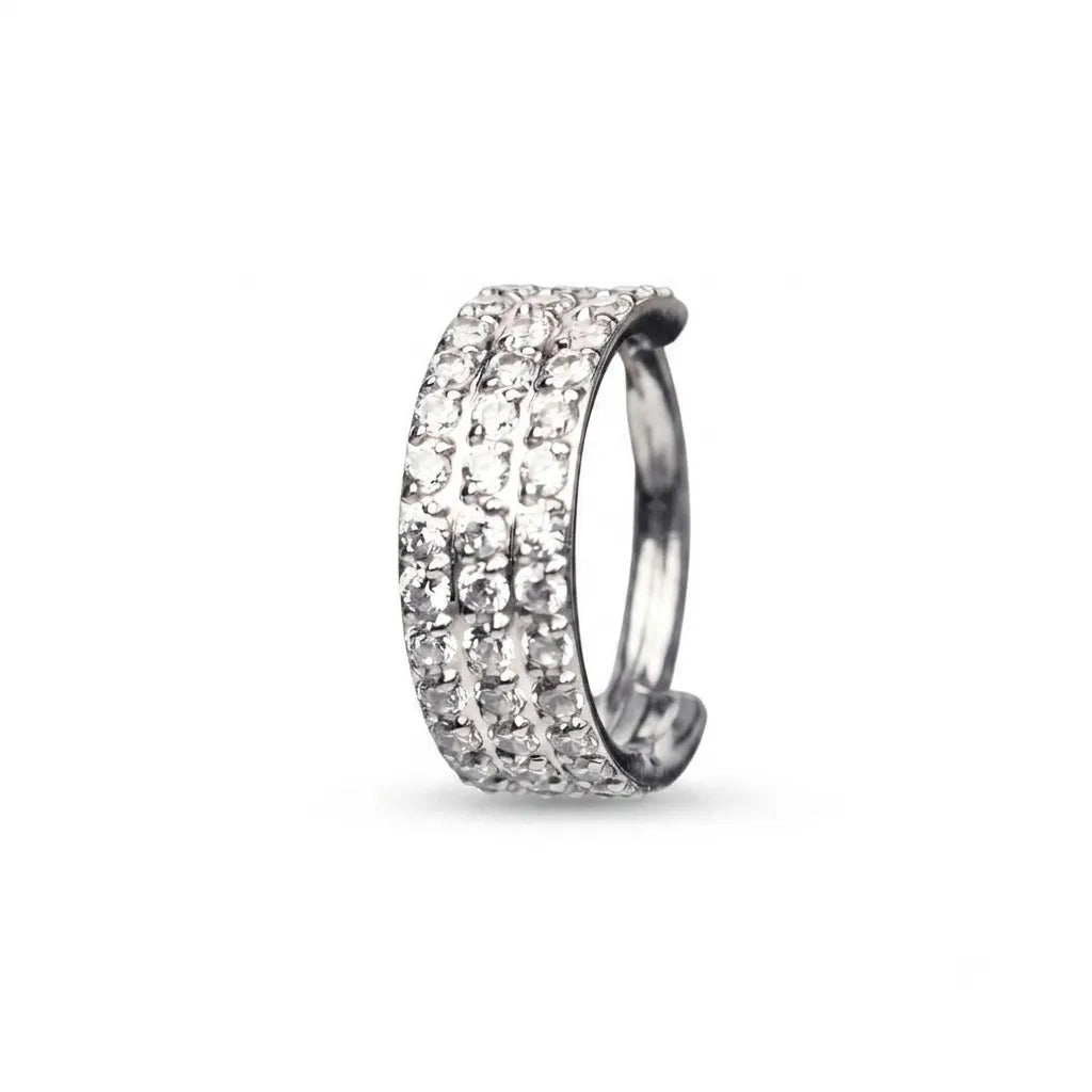 A silver-toned huggie ring featuring three rows of sparkling clear pavé gemstones, shown on a clean white background.