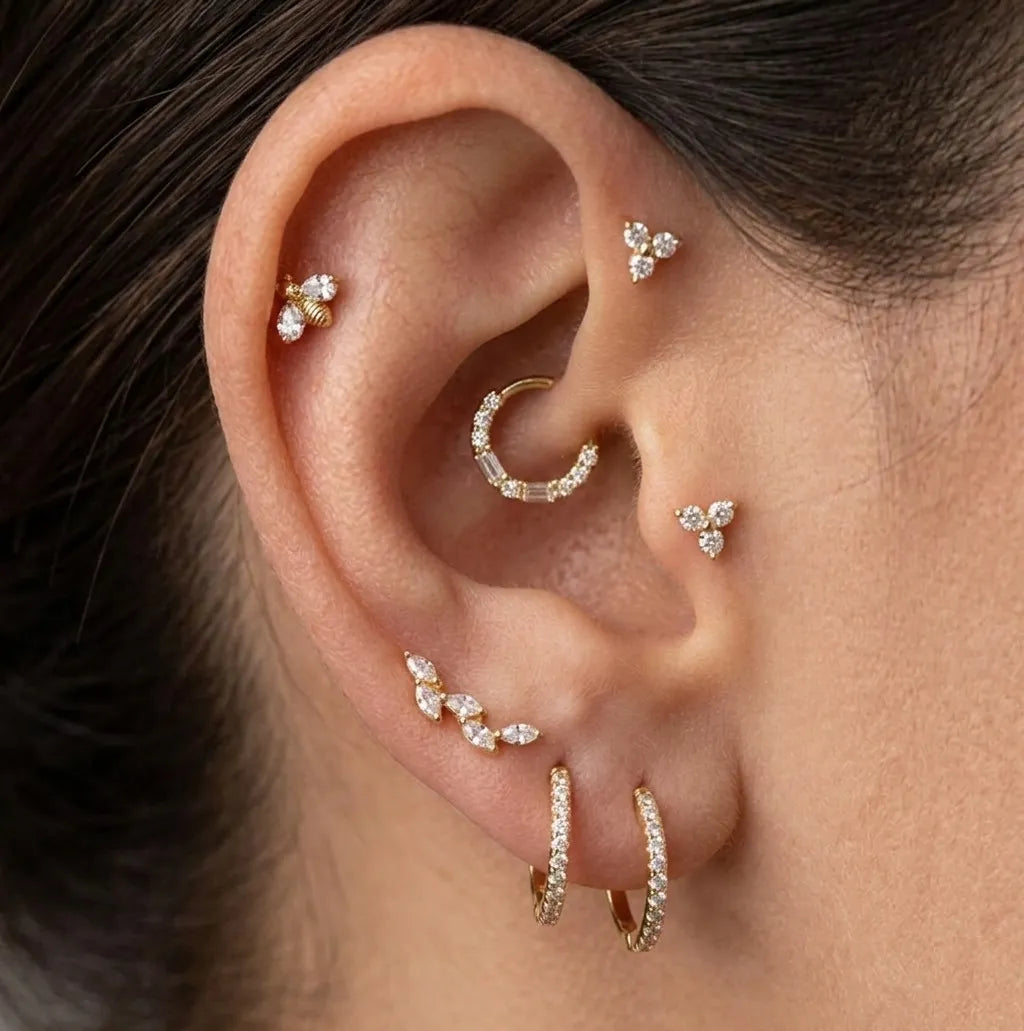 Close-up of an ear with multiple gold and diamond earrings.