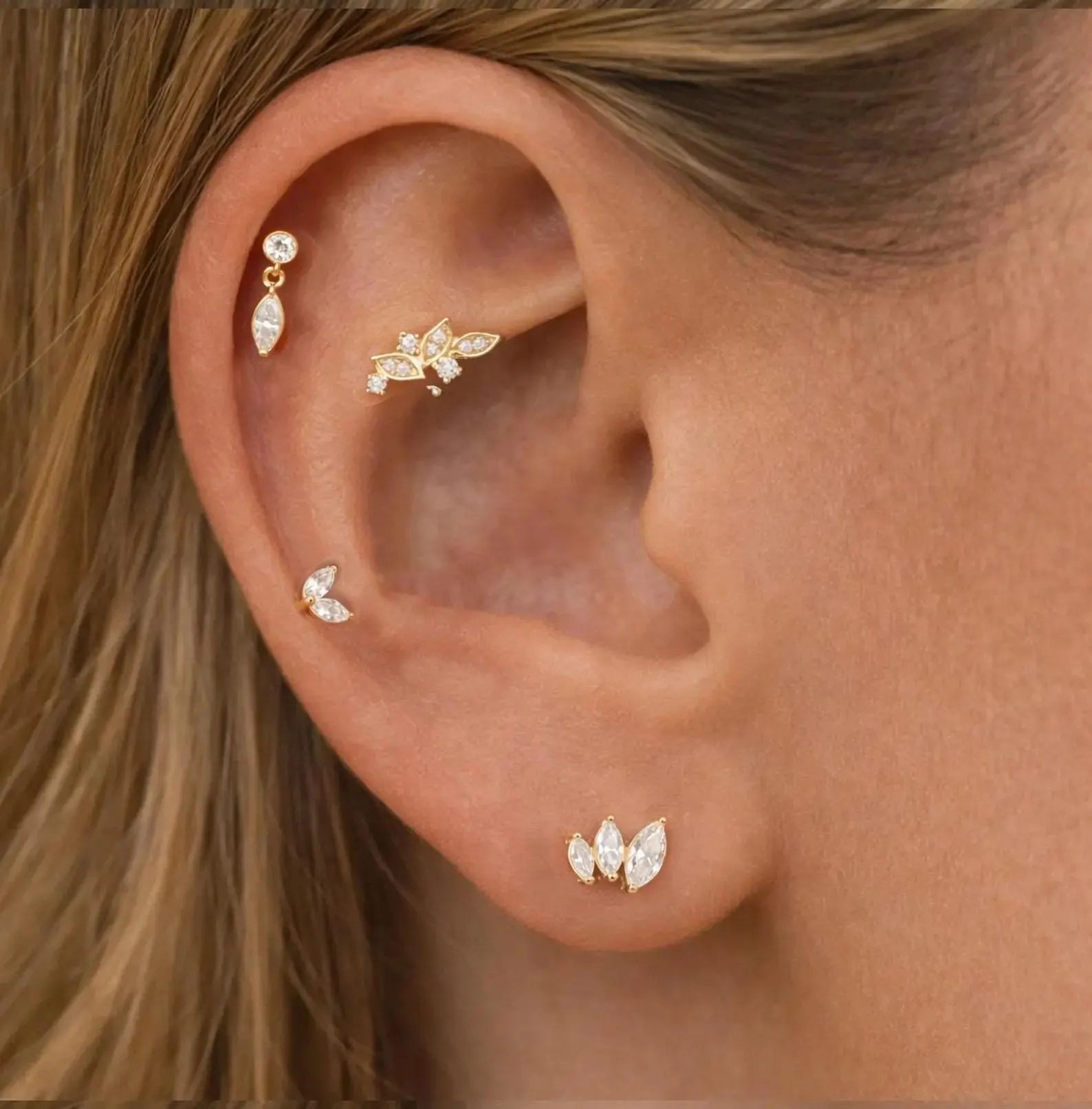 Close-up of an ear with gold earrings