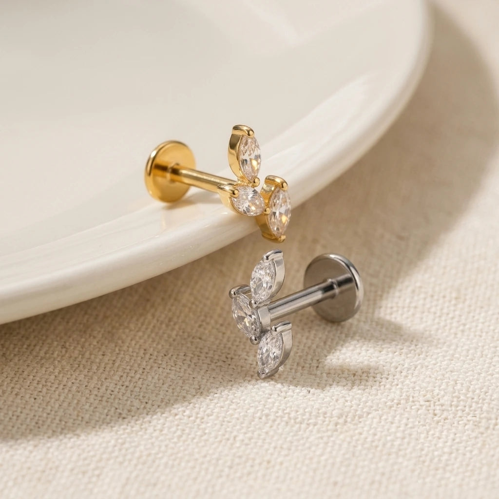 Gold and silver earrings on a beige fabric background