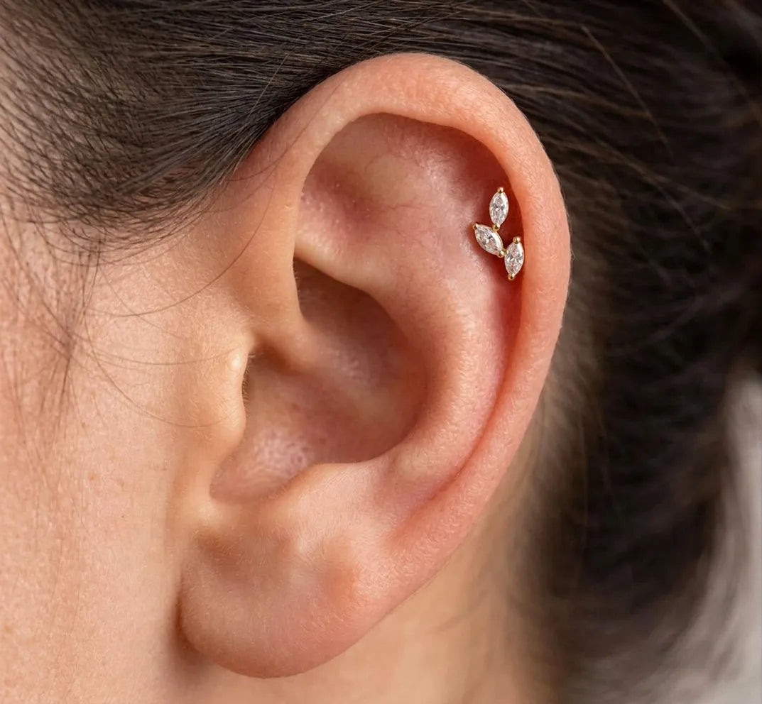 Close-up of an ear wearing a diamond earring with a blurred background