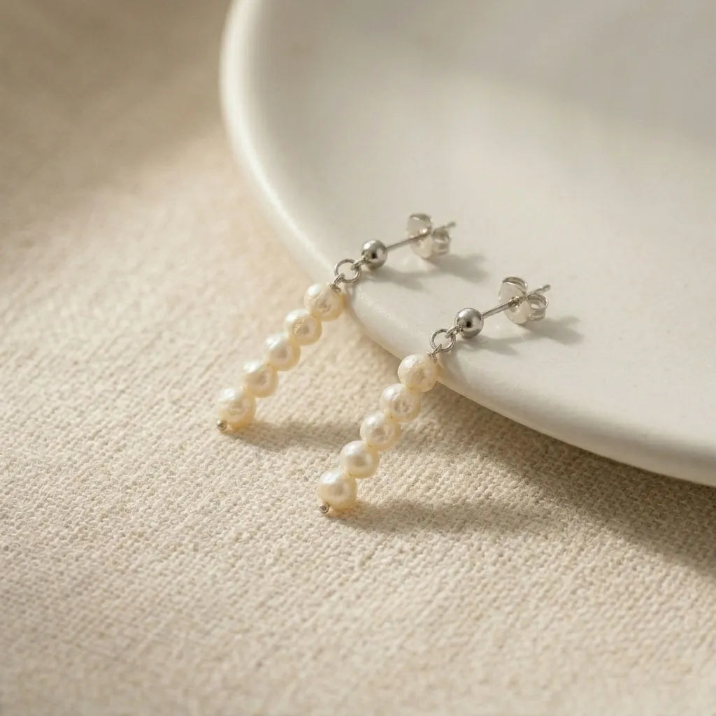 Detail view of Lys Doré silver pearl stud drop earrings showing pearl strand and silver butterfly back