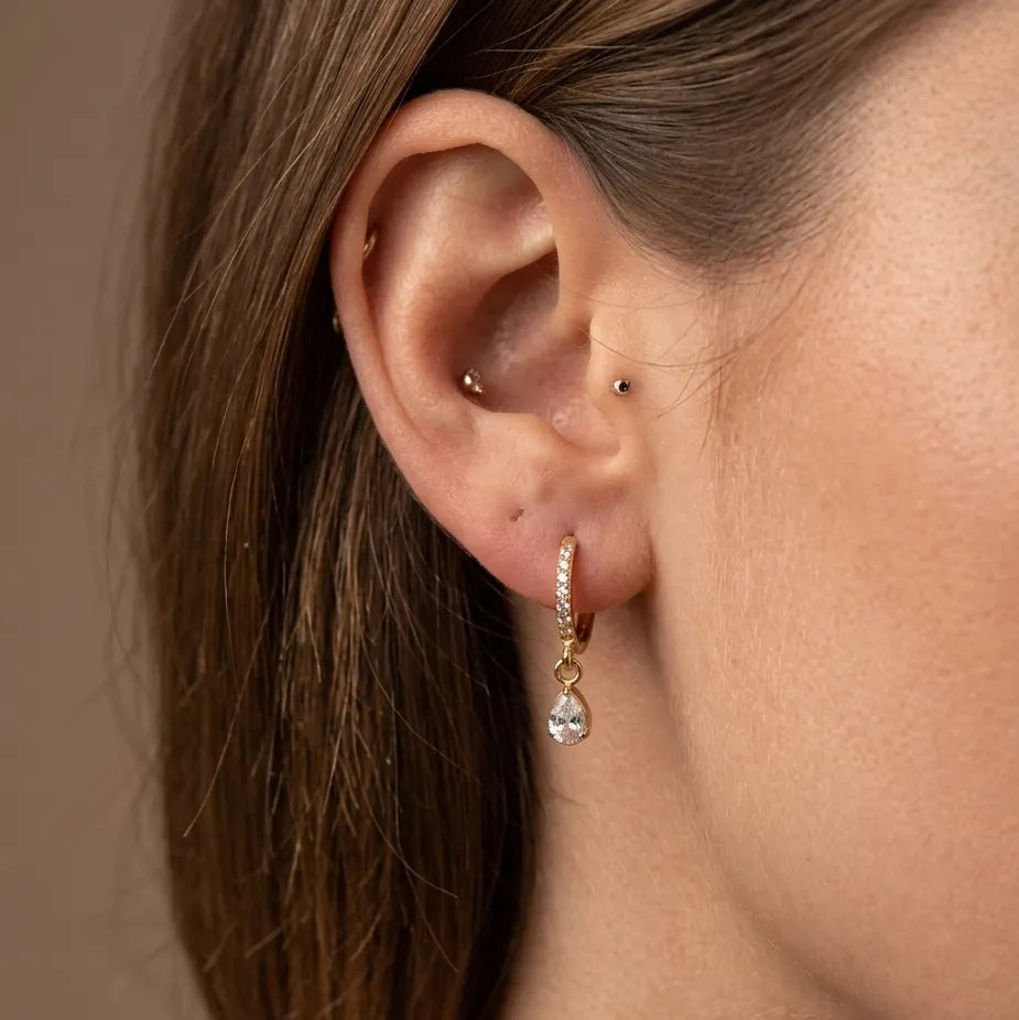 Gold teardrop CZ bezel charm pavé hoop earring worn in lobe piercing
