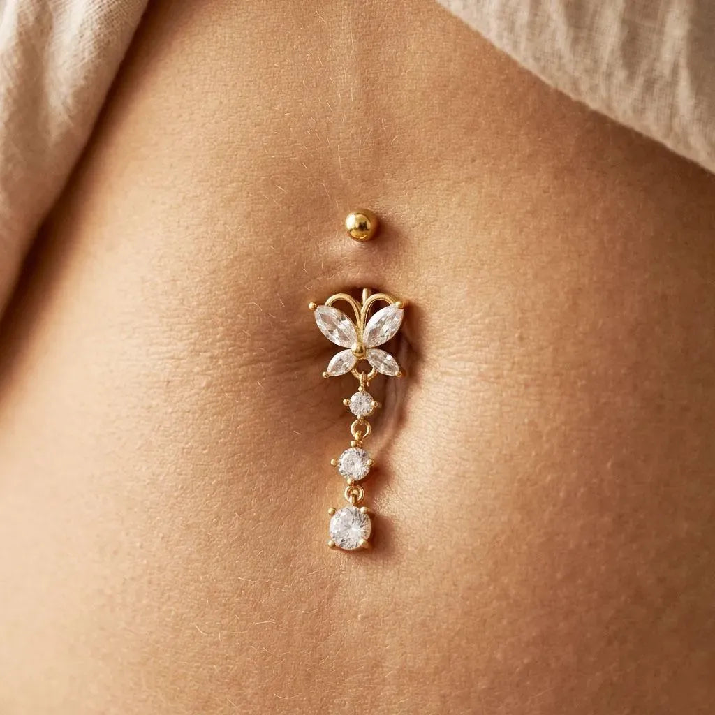 Butterfly-shaped belly button ring with gemstones on a person's belly.