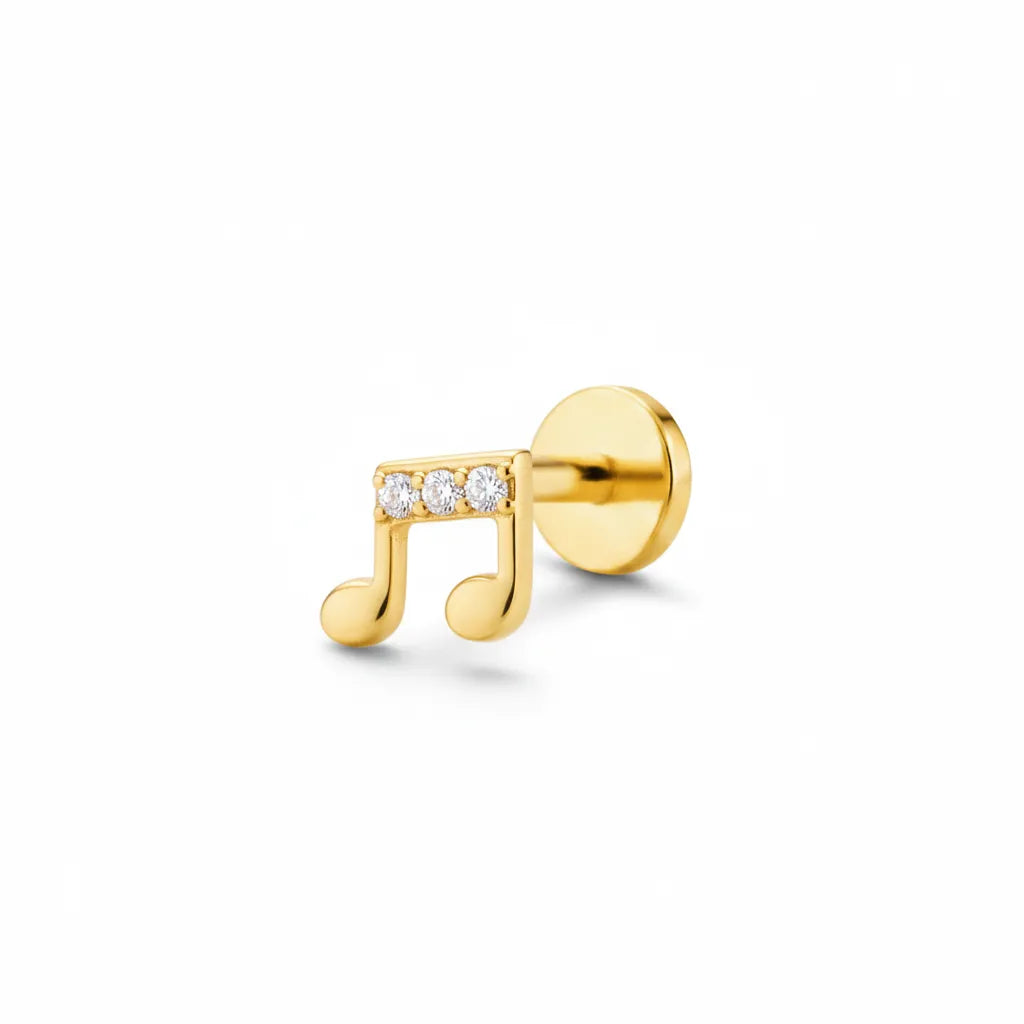 Gold earring shaped like a music note with embedded diamonds on a white background