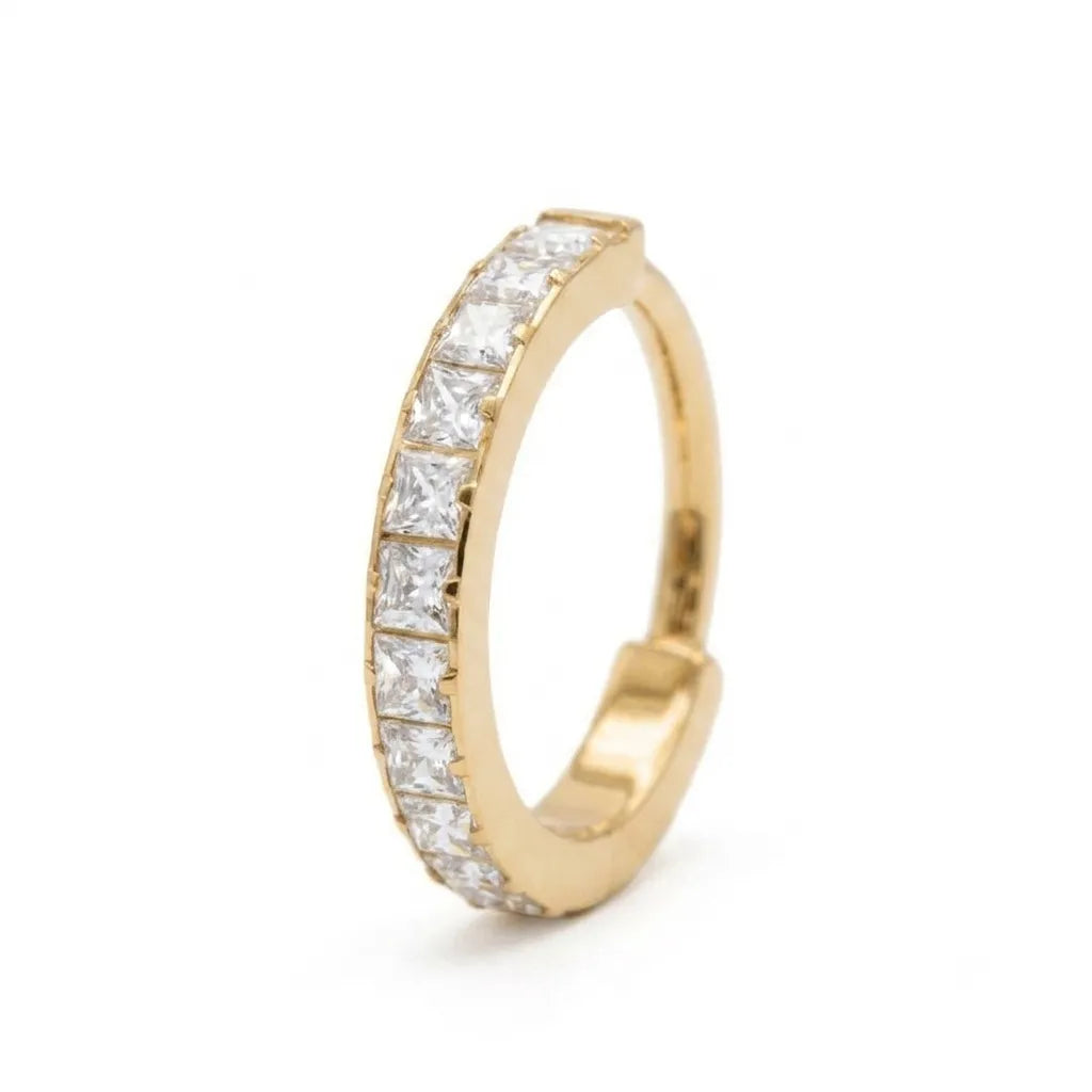 A gold huggie hoop ring featuring a continuous row of princess-cut clear stones, shown on a clean white background.
