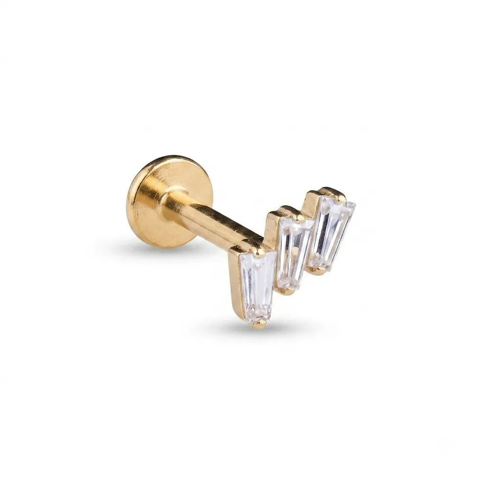 A gold post cartilage piercing stud featuring three clear baguette-cut crystals, shown on a clean white background.