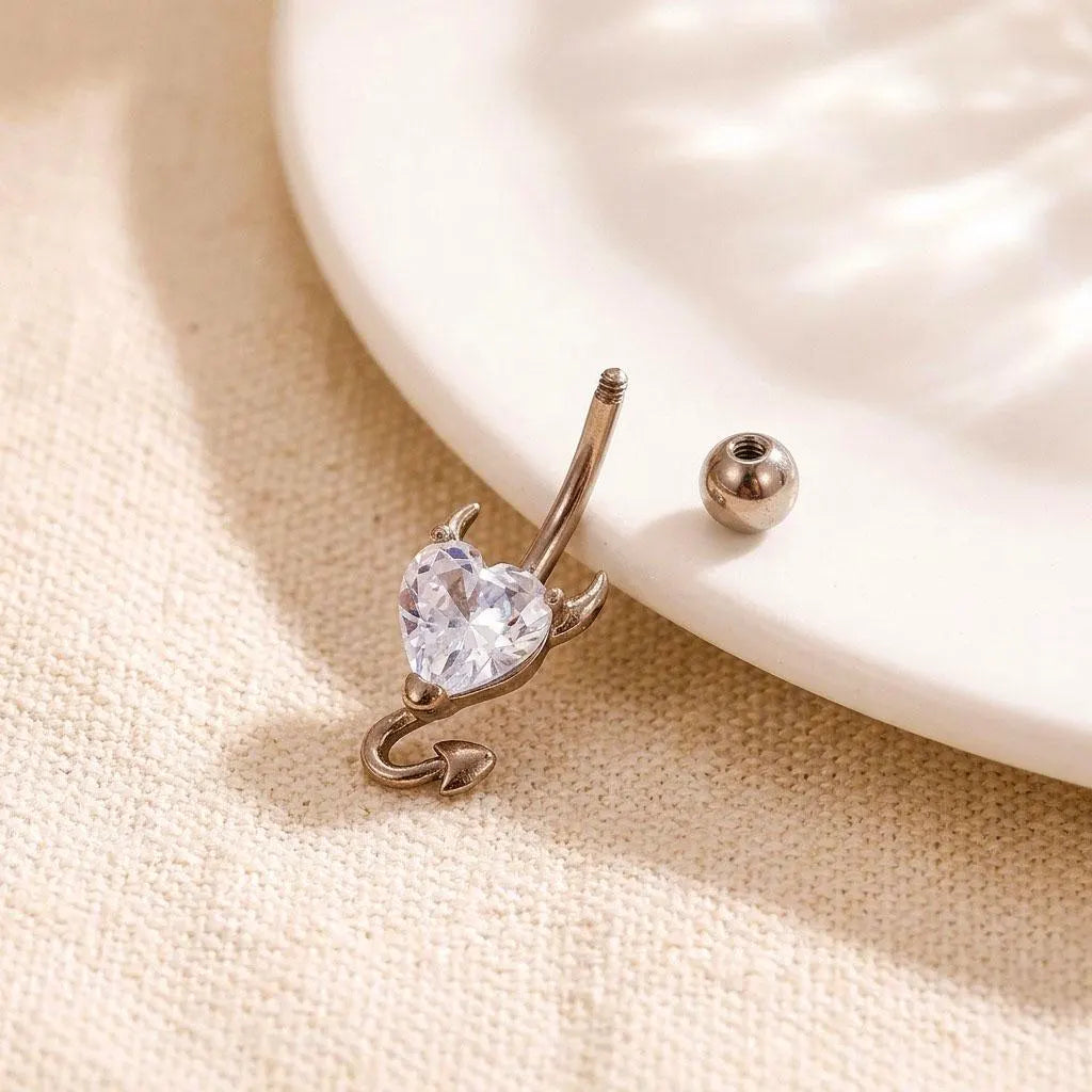 Gold nose ring with a heart-shaped gemstone on a beige fabric background