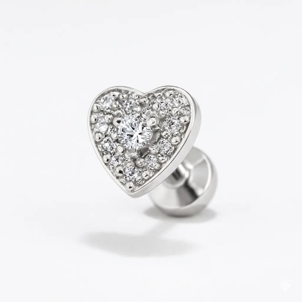 Heart-shaped silver earring with embedded crystals on a white background