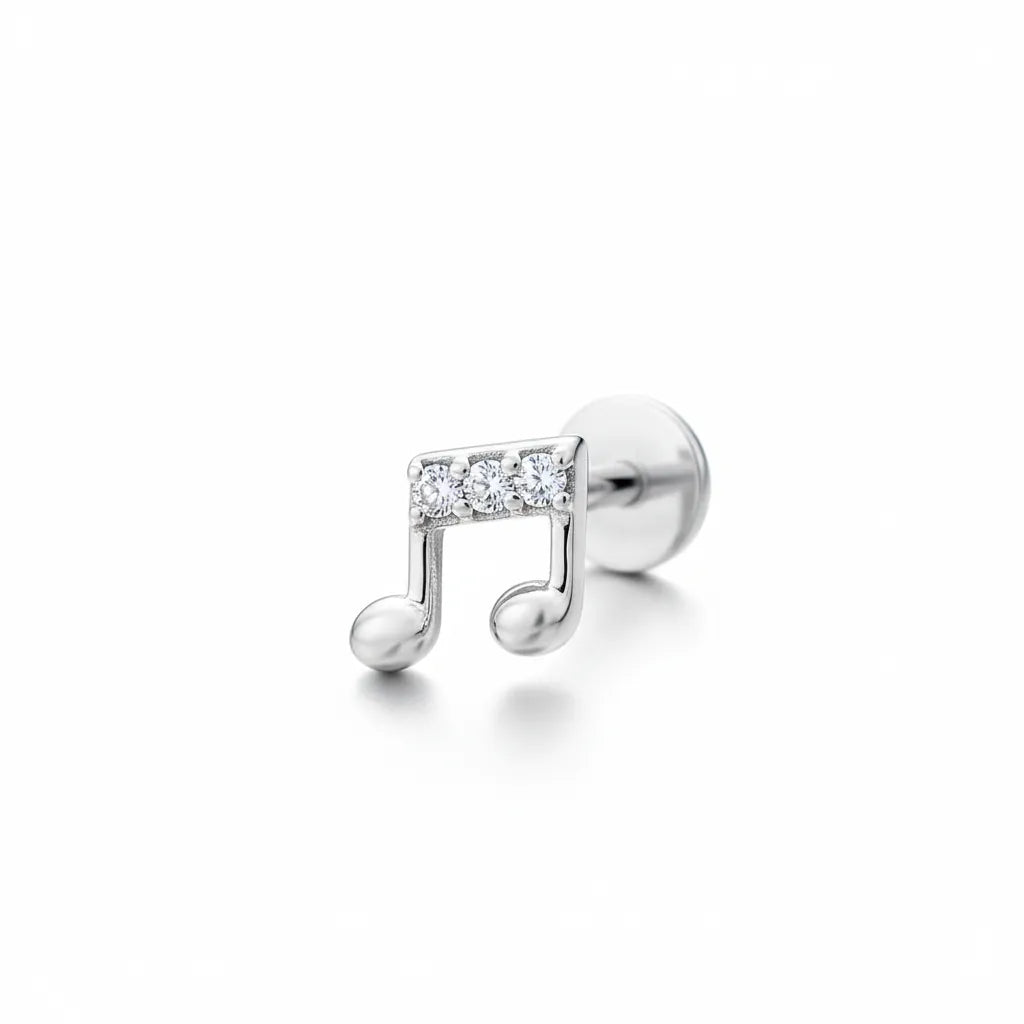 Silver music note earring with clear gemstones on a white background