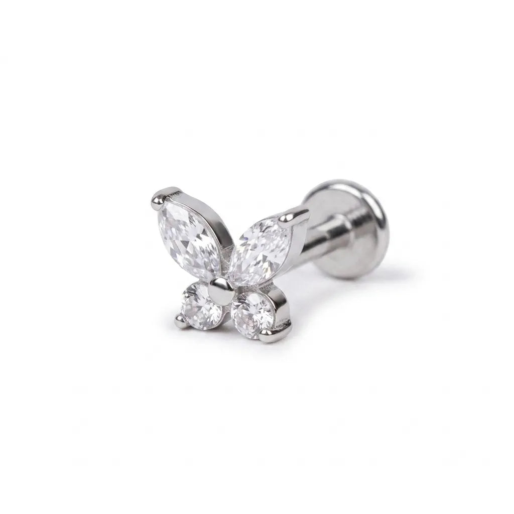 Butterfly-shaped earring with clear gemstones on a white background