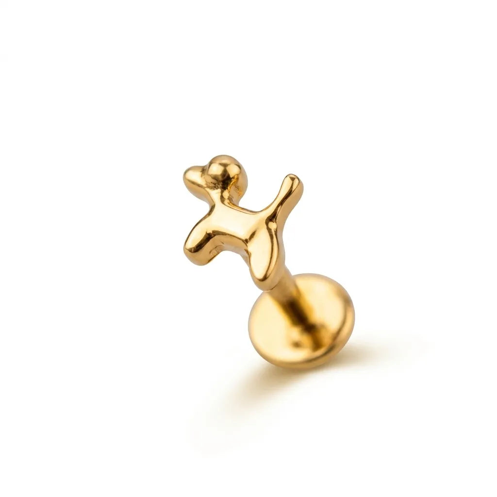 Gold dog tragus piercing on a white background