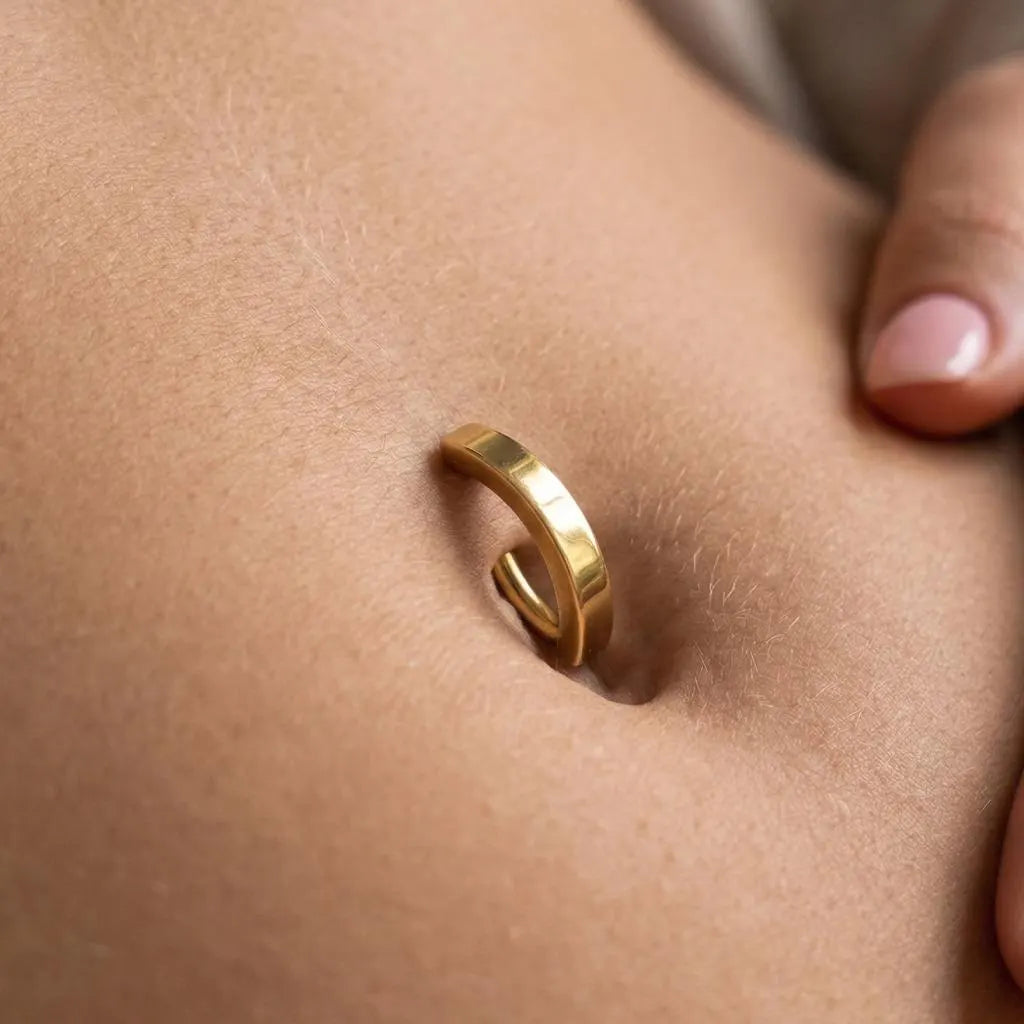 Gold belly bar on a person's belly