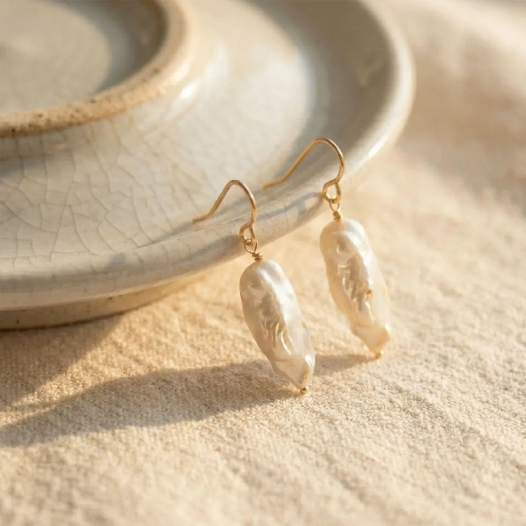 Detailed macro shot of the shimmering pearl surface and the 14ct gold filled hooks of the Perla Opaline collection.