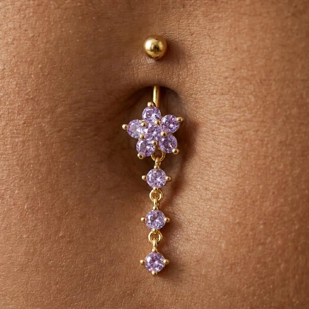 Gold earring with purple gemstones worn on a person's ear.
