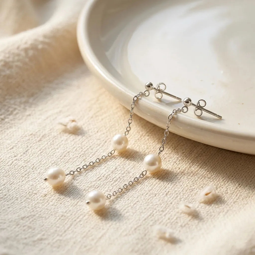 Pair of sterling silver long chain drop earrings featuring white round pearls