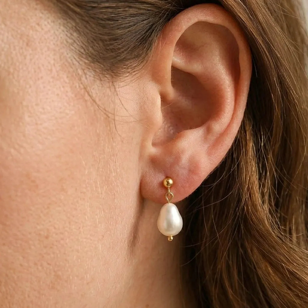 Close-up of Vita Perlata freshwater pearl double drop stud earrings on model's ear