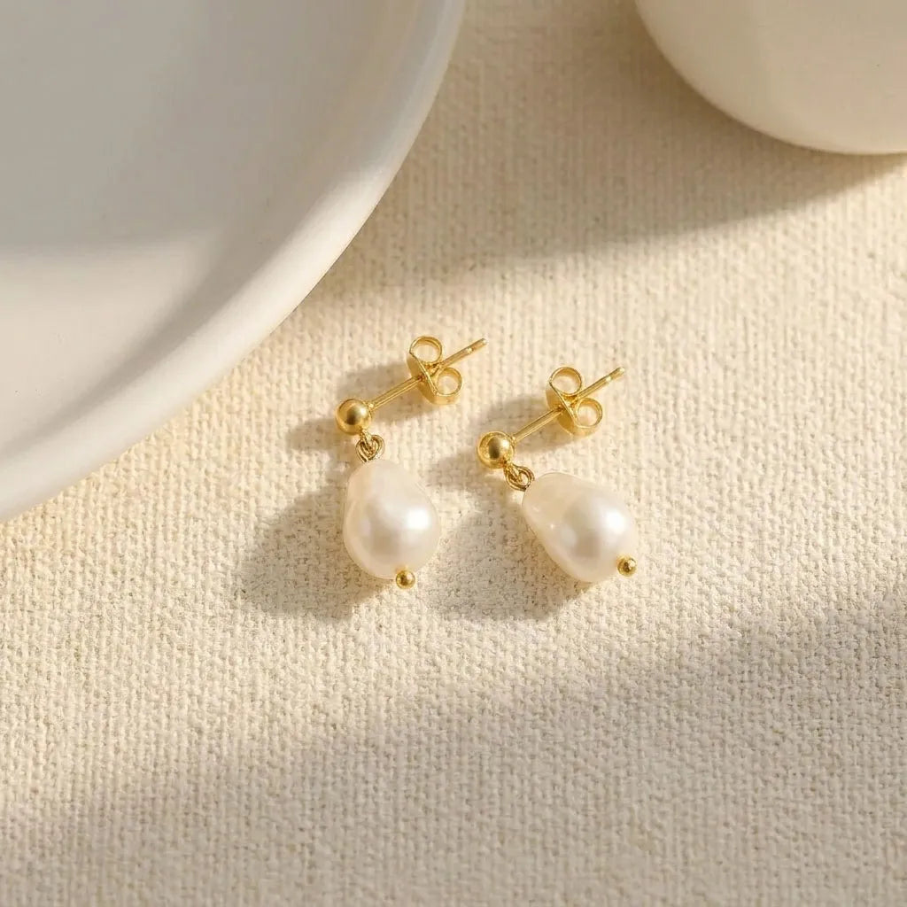 Angled view of Vita Perlata gold pearl drop studs showing two stacked oval pearls